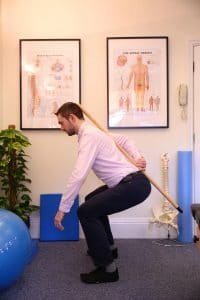 Chiropractor shows correct bending technique for back pain and sciatica